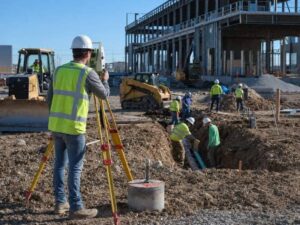 Construction surveyor using a total station to establish site control for multiple contractors in Frisco TX